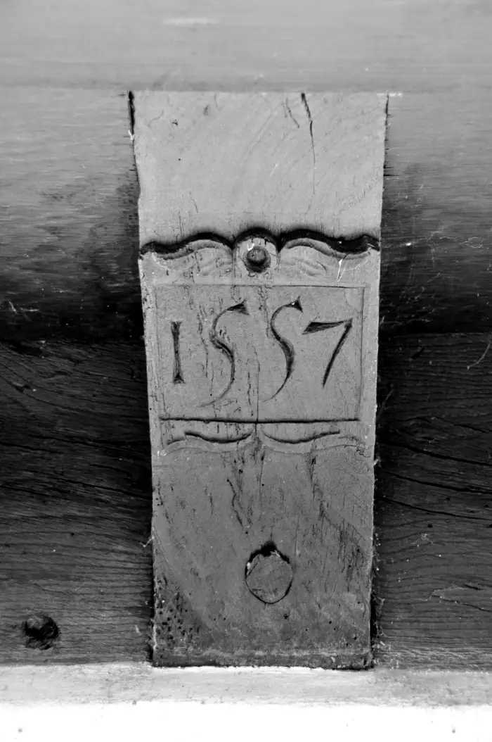 Holzbalken mit der eingeschnitzten Jahreszahl 1557