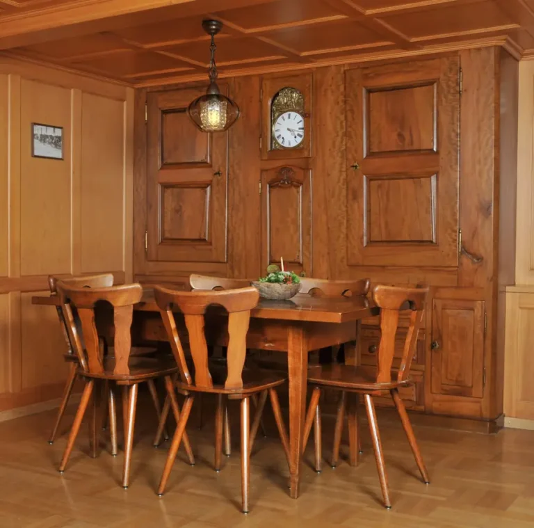 Tisch in der Gaststube mit Holztäfer und Wanduhr